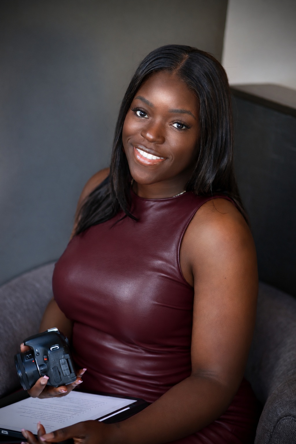 Bri, founder of MissBriMichelle Media, smiling and holding her camera