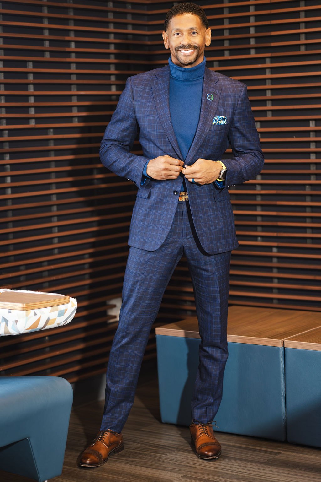 Logan standing in a navy suit