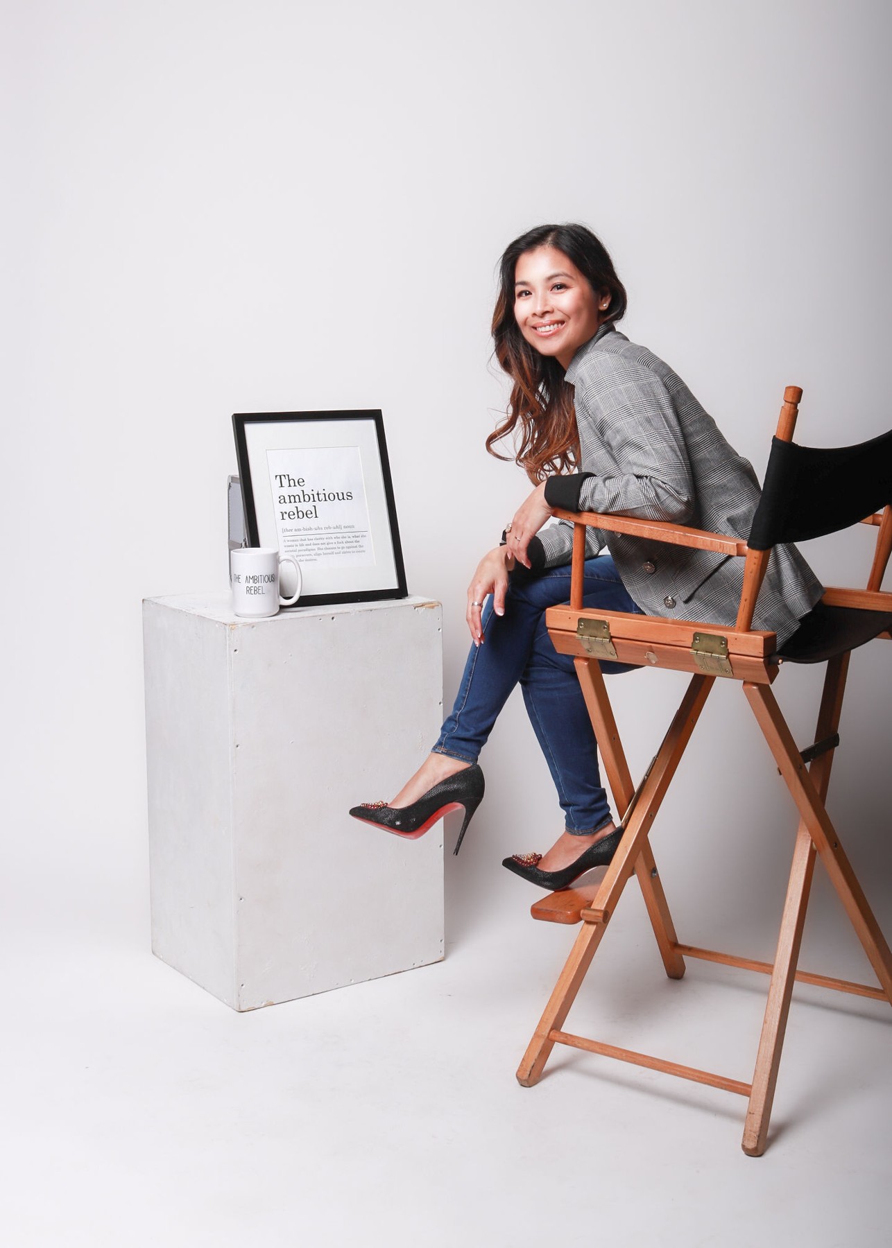 Lynn seated beside a framed sign